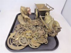 A tray of horse brasses and two brass horse ornaments