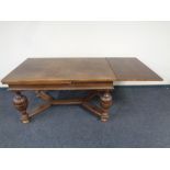 An Edwardian oak pull out dining table on bulbous legs