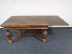 An Edwardian oak pull out dining table on bulbous legs