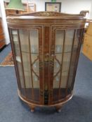 A walnut Chinoiserie bow fronted double door display cabinet