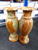 A pair of onyx floor standing vases,