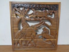 A 20th century African carved hardwood panel depicting wildlife