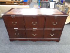 A six-drawer filing chest with brown tooled leather inset panel in mahogany finish