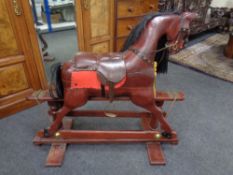 A wooden rocking horse on stand