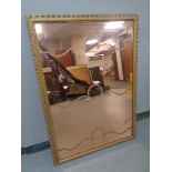 A copper tinted etched mirror in a gilt frame