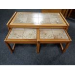 A nest of three 20th century teak tiled topped tables