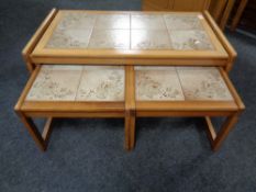 A nest of three 20th century teak tiled topped tables