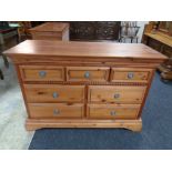 A contemporary pine seven drawer chest