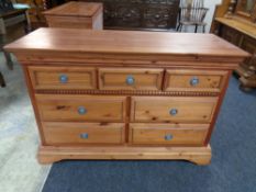 A contemporary pine seven drawer chest