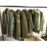 A rail of Second World War and later military uniforms comprising combat smock,