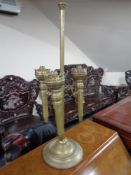 An antique brass three-way oil lamp