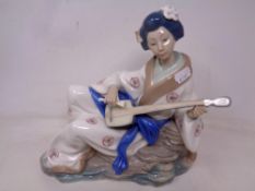 A Nao figure of a Geisha playing a stringed instrument