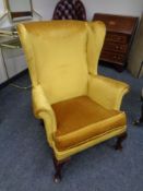 A 20th century wingback armchair in gold dralon