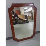 A late 19th century shaped mahogany framed bevelled overmantel mirror