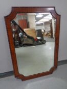 A late 19th century shaped mahogany framed bevelled overmantel mirror