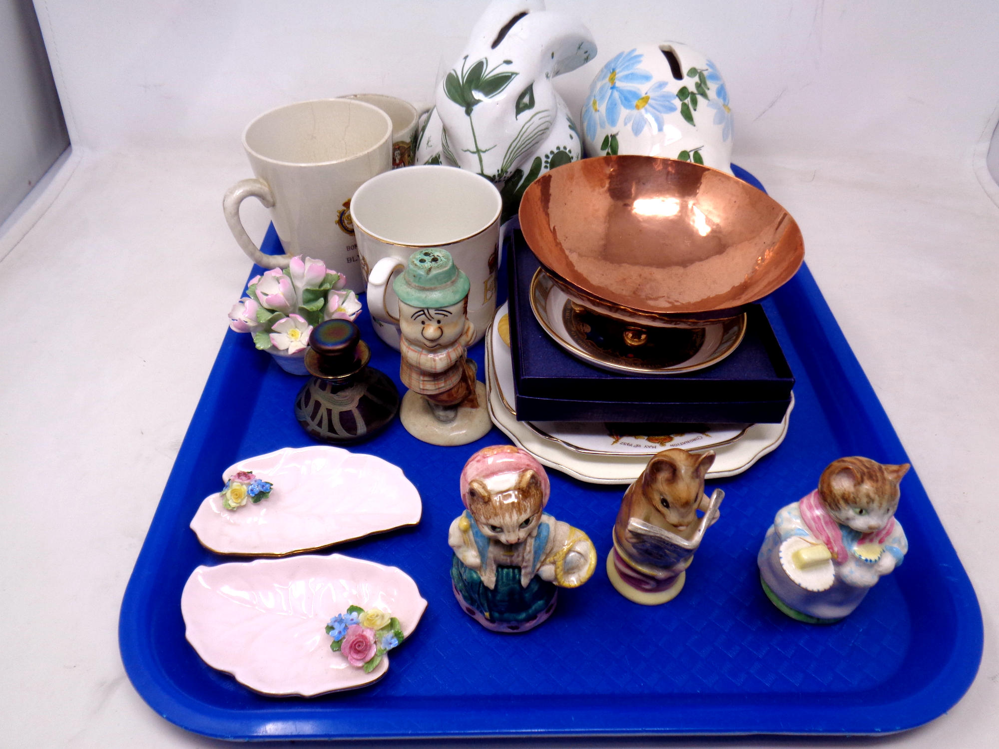 A tray of Beatrix Potter figures, pottery money boxes, Isle of Wight glass scent bottle,