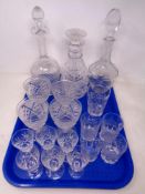 A tray of three cut glass decanters with stoppers, set of four wine glasses,