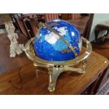 A gemstone globe on brass stand