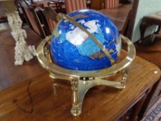 A gemstone globe on brass stand