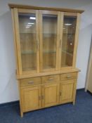 A Morris Furniture oak triple door display cabinet fitted cupboards and drawers beneath