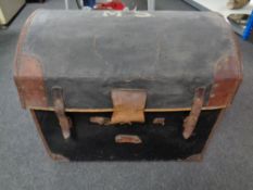 An antique canvas and leather dome-topped shipping trunk.