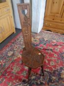 A carved oak spinning chair dated 1913