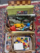 Two boxes containing wooden chess board, building blocks, crayons, xylophone, wooden trains,