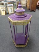 A Moroccan style brass and glass hexagonal counter topped display cabinet in purple velvet