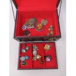 A wooden jewellery box and contents to include costume brooches,