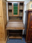 An Edwardian oak roll topped bureau bookcase fitted with shelves