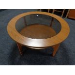 A 20th century Schreiber teak effect circular two tier coffee table with glass panel