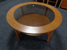 A 20th century Schreiber teak effect circular two tier coffee table with glass panel