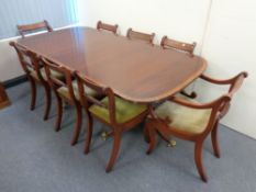 A Regency style inlaid mahogany twin pedestal dining table with leaf,