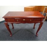 A console table fitted with a drawer in a mahogany finish