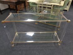 A contemporary metal framed two-tier glass-toped console table with matching occasional table.