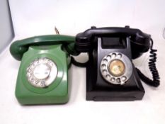 Two vintage Bakelite and plastic cased telephones, one black and one green.