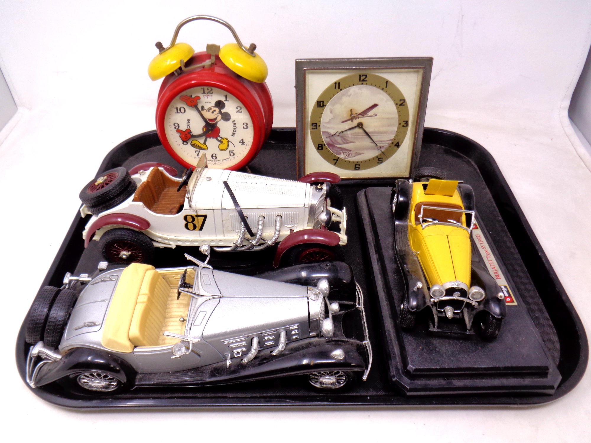 A tray of three Burago die cast classic cars together with a Mickey Mouse alarm clock and a further