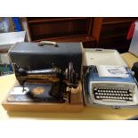 A vintage Singer sewing machine together with typewriter in case