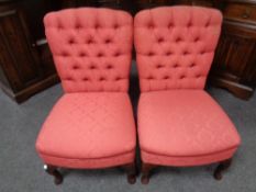 A pair of contemporary buttoned bedroom chairs in red fabric