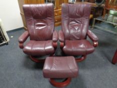 A pair of Himolla wood framed manual reclining swivel armchairs upholstered in a Burgundy leather