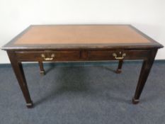 An Edwardian two drawer library table with leather inset panel