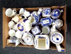 A box containing Ringtons ceramics including willow pattern china, commemorative teapots and mugs.