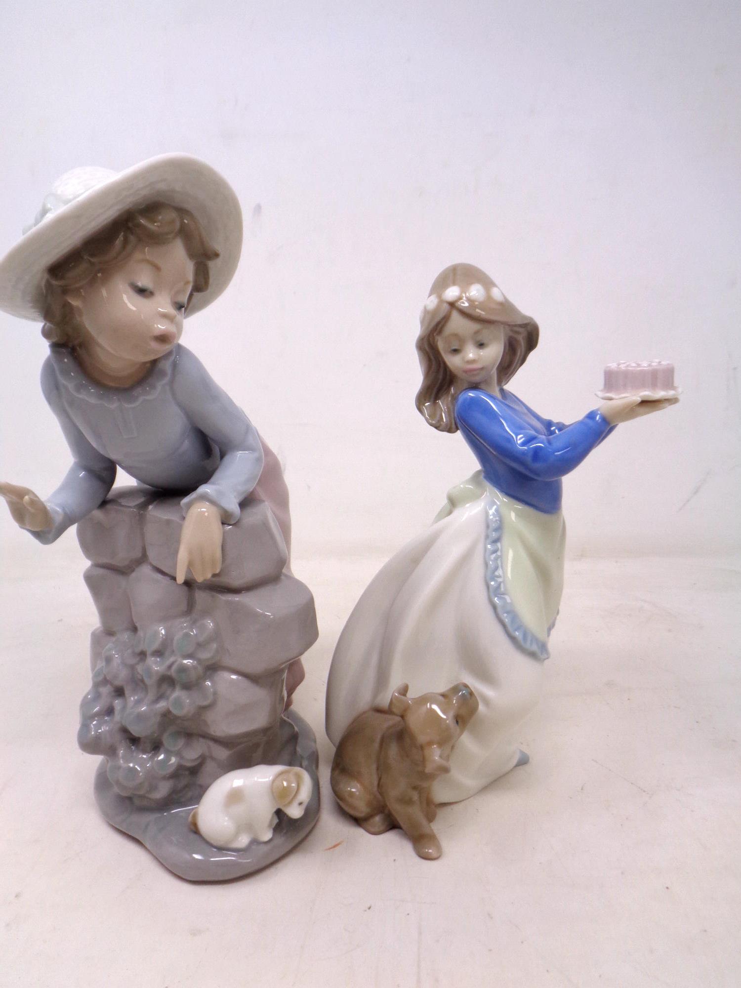 Two Nao figures of girls with dogs