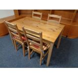 A pine kitchen table together with four chairs