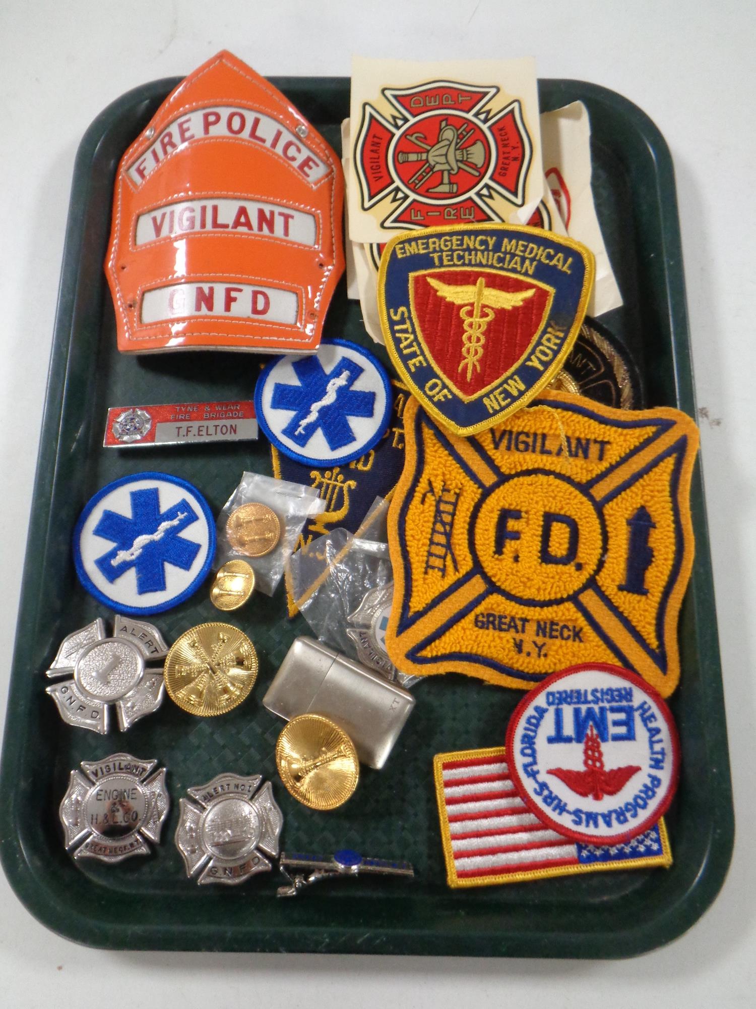 A tray of fire department badges and other decorations,