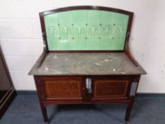 A late Victorian inlaid mahogany marble topped tiled washstand on raised legs
