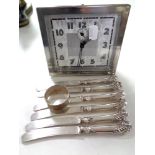 A twentieth century Scottish LSM chrome plated alarm clock together with a set of six handled