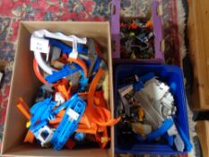 Three boxes containing Hot Wheels HW racetrack and cars, Tomica Hypercity track and trains,