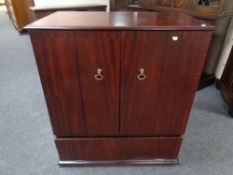 A double door television cabinet in mahogany finish