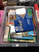 A plastic storage crate with lid containing travel guides